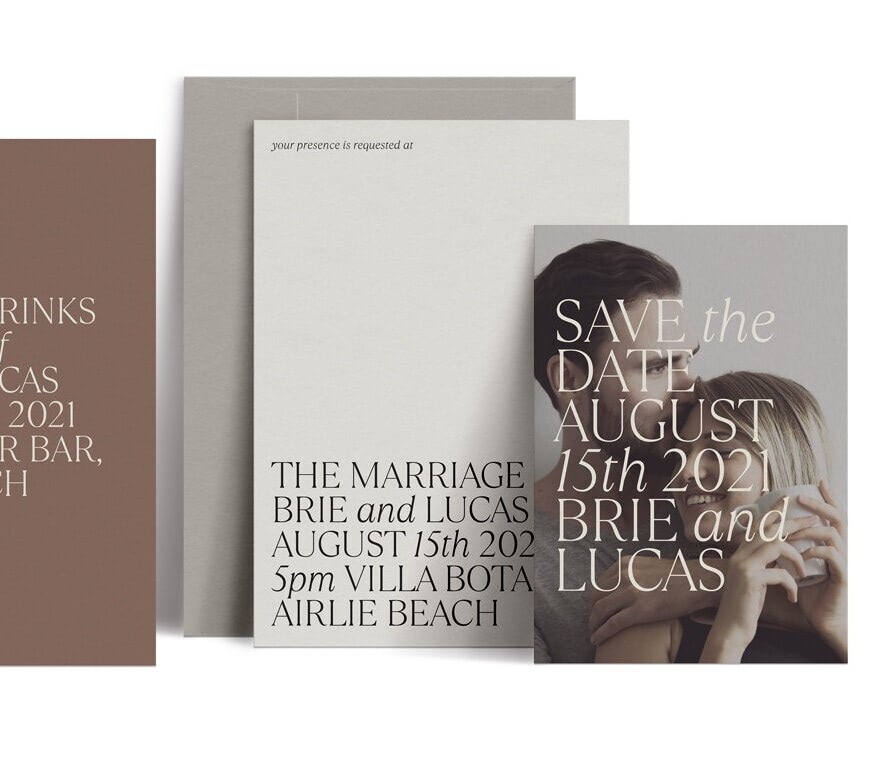 A set of printed wedding invitations and save the dates with a photo of the couple and neutral colored pieces of paper