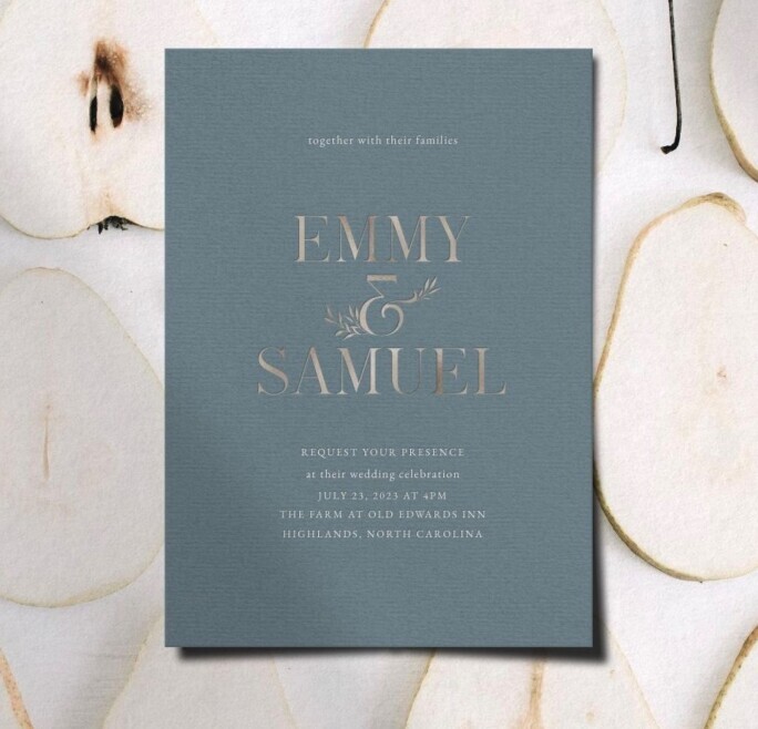 blue wedding invitation with serif typography, “Emmy and Samuel” names, minimalist elegant design, and neutral stone background