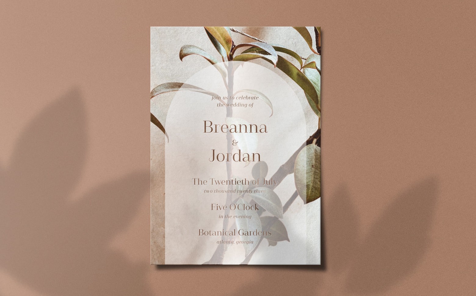 A botanical wedding invitation with stems of leaves and a brown background